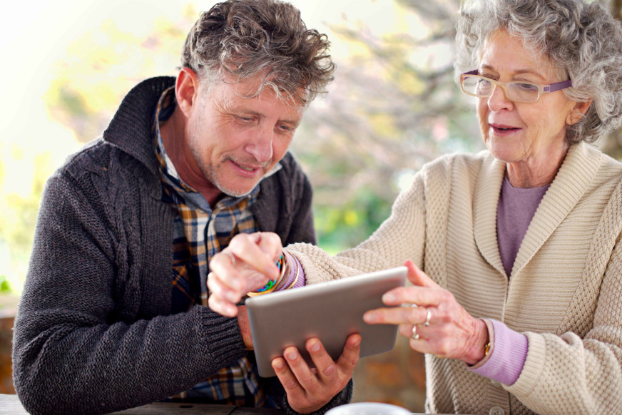 An elderly mother is helped by her son with her financial affairs.