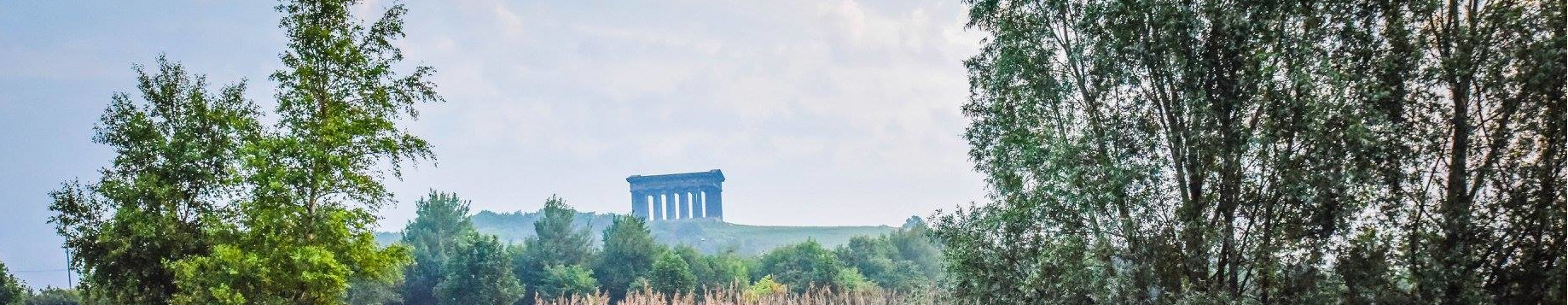 The Penshaw monument stand in the distance framed between trees. Photo by Trevor Liddell